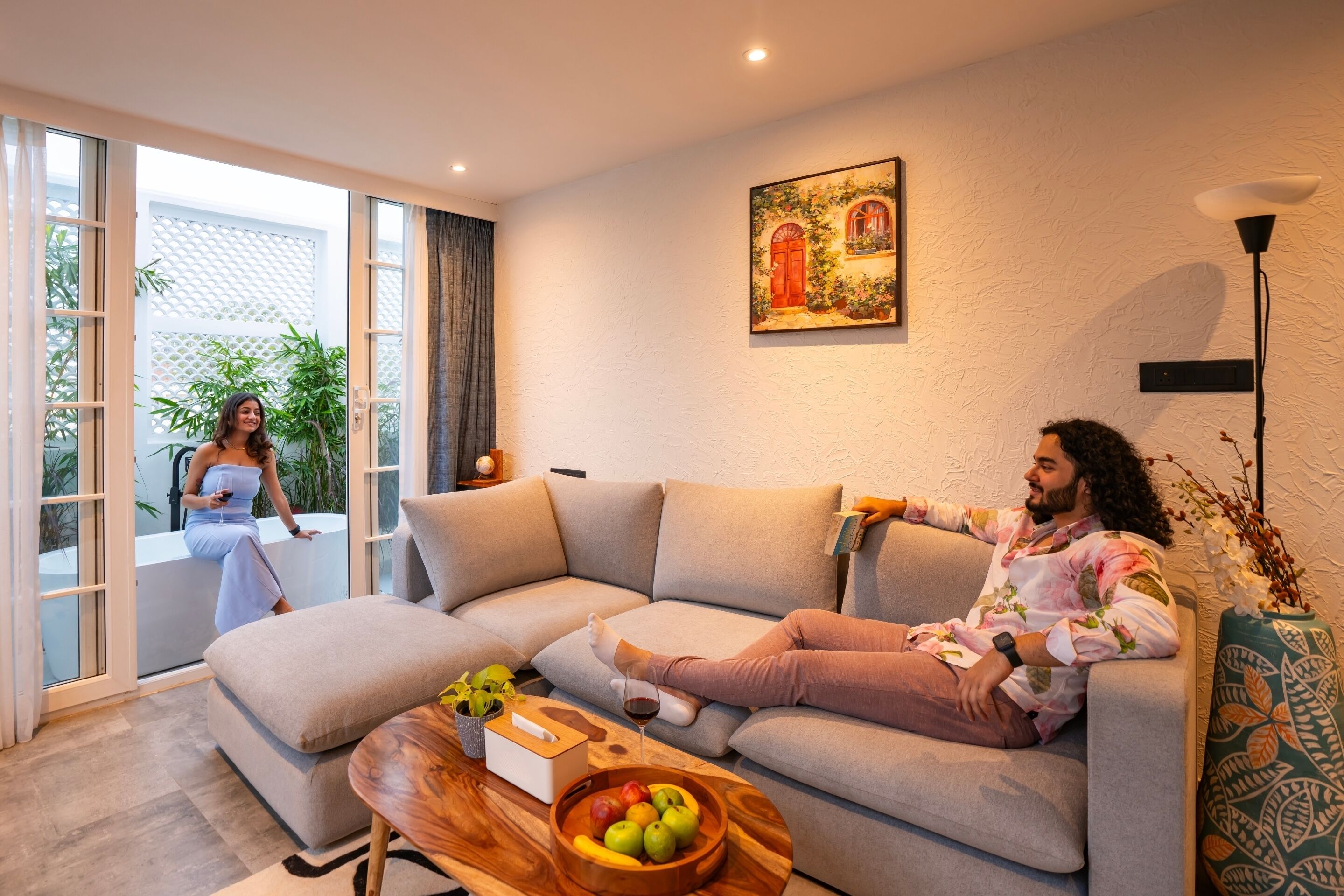 Ein modernes Wohnzimmer mit einem Ecksofa, einem Couchtisch mit Früchten und einem Bild an der Wand.