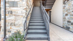 A staircase with stone walls on either side and a metal railing. - Moab Sage Creek Arches Rest (Moab)
