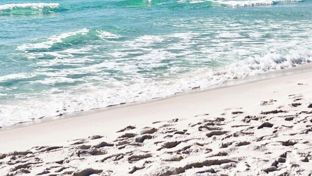 Una spiaggia con acque cristalline turchesi e sabbia bianca.