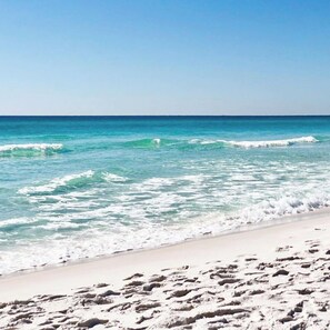 A beach with clear turquoise water and white sand.