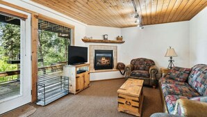 A living room with a fireplace, a television, a sofa, and a coffee table.