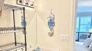Un bagno con un lavandino bianco, un water e una zona doccia. È presente un porta asciugamani e uno specchio sopra il lavandino.