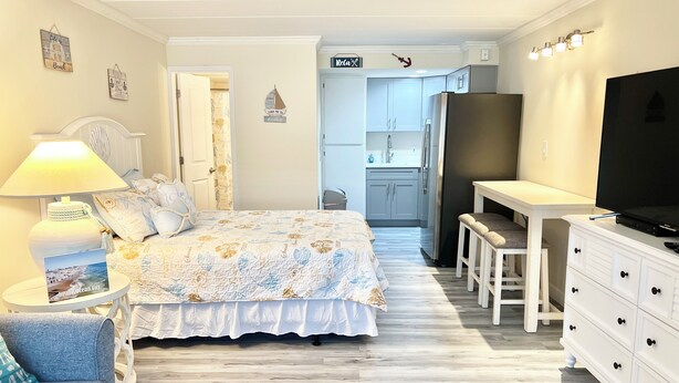 Una camera da letto con un letto, un comodino, una lampada e un televisore.