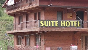 A two-story wooden building with balconies and a stone facade, labeled as a 'SUITE HOTEL'. - Uzungöl (Çaykara)