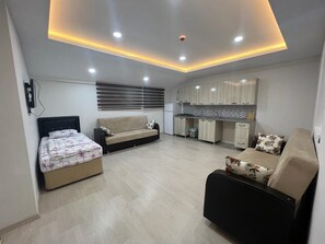 A modern apartment with a kitchenette, a sofa, a bed, and a dining area. - Uzungöl (Çaykara)
