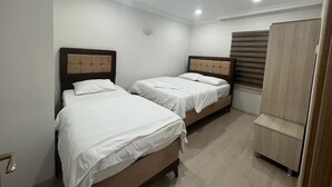 A room with two single beds, a wooden wardrobe, and a window with blinds. - Uzungöl (Çaykara)