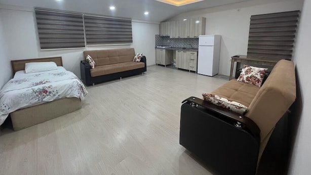 A modern apartment with two sofas, a bed, and a kitchen area. - Uzungöl (Çaykara)