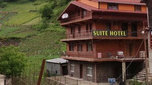 A multi-story building with a sign reading "SUITE HOTEL" in the foreground. - Uzungöl (Çaykara)