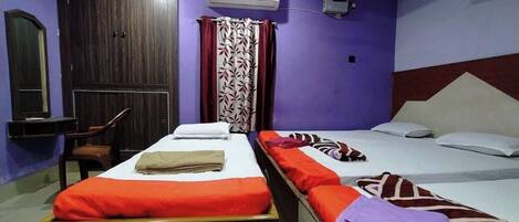 A room with two beds, a desk, and a chair.