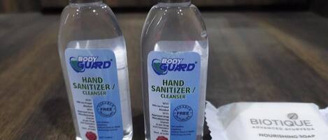 Two bottles of Body Guard hand sanitizer/cleansers and a bar of Biotique nourishing soap on a wooden surface.