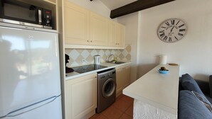 A compact kitchen with a microwave, washing machine, and a clock on the wall. - Appartement "rooftop" Avec Très Grande Terrasse à 2km de la mer (Roquebrune-sur-Argens)