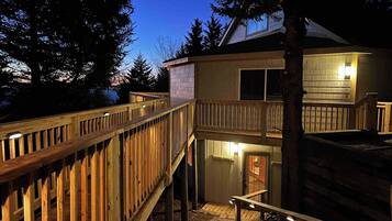 A two-story wooden structure with a balcony and a staircase leading to the upper level.