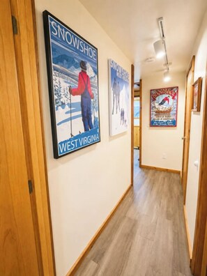 A hallway with wooden flooring and walls adorned with framed posters. - Hutch 1- 2 Min Walk to Slopes, Great Mountain View (Slaty Fork)