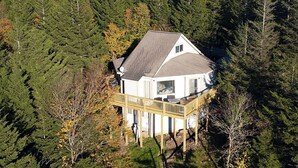 A house with a deck, surrounded by dense forest. - Hutch 1- 2 Min Walk to Slopes, Great Mountain View (Slaty Fork)
