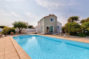 A swimming pool with a house in the background.