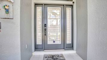A grey double door with a welcome mat in front.