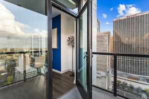 Et moderne hotelværelse med en stor glasdør, en blå væg, en potteplante og udsigt til Marriott Marquis.