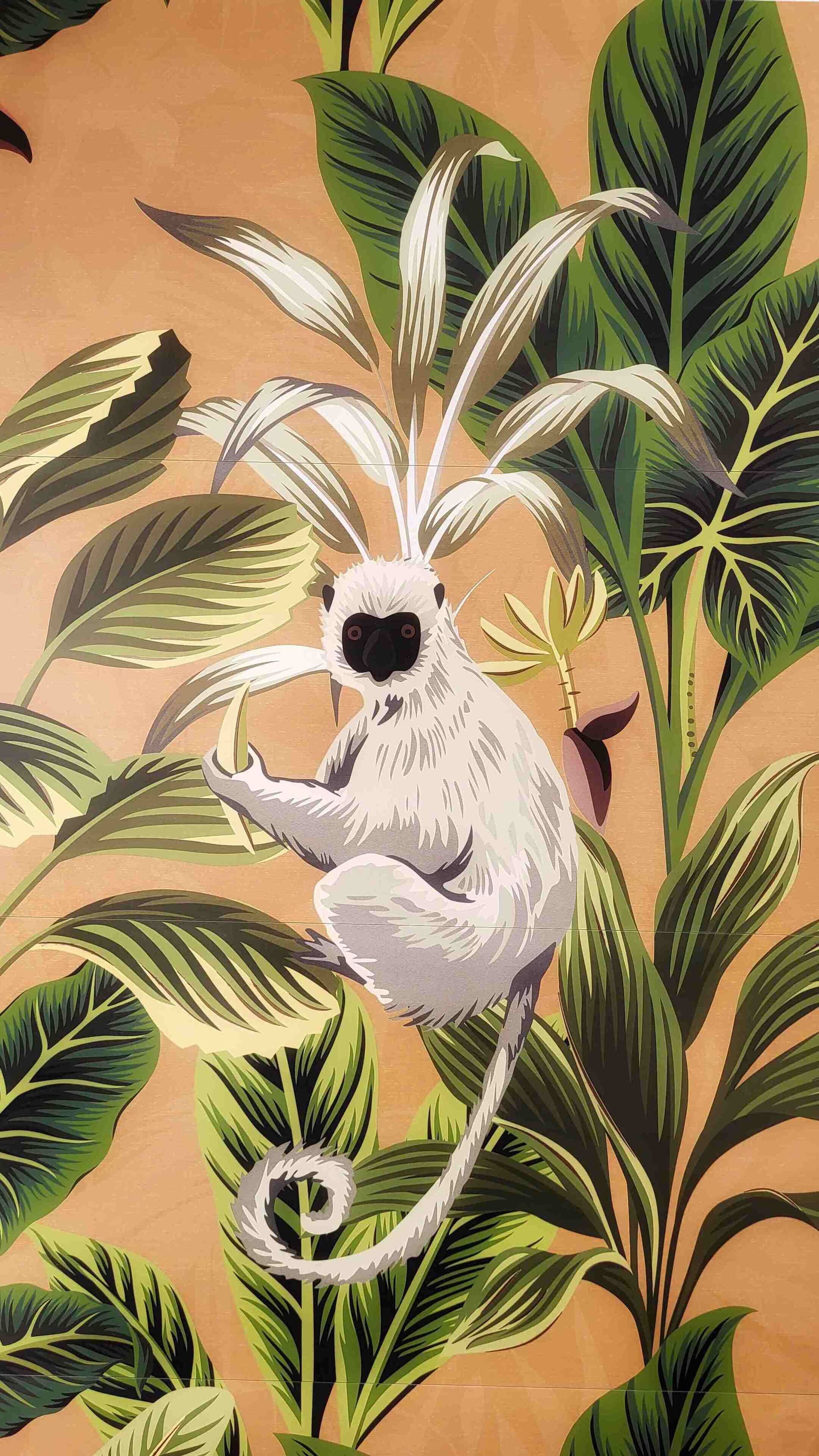 A mural of a white monkey with a curled tail, surrounded by large green leaves.