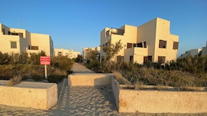 A pathway leading to modern buildings with a sign indicating private access for residents.