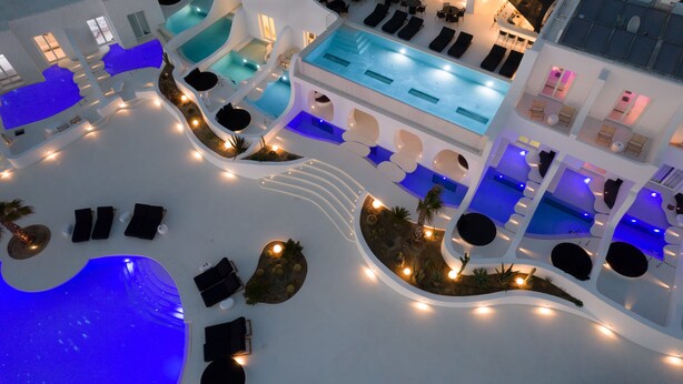 A multi-level indoor pool area with various seating arrangements and lighting. - Million Stars Mykonos (Mykonos)