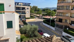 Zona residencial con edificios de varios pisos, una carretera sinuosa y coches estacionados.