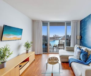 A modern living room with a city view, a large window, and a wall-mounted map.
