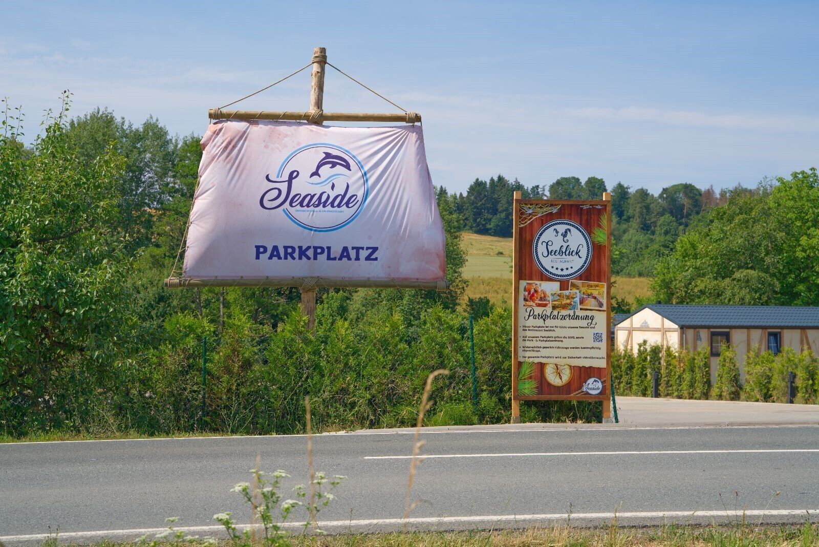 A sign for 'Seaside Parkplatz' with a logo and a QR code for 'Teeblick'.