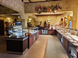 Amplia zona de buffet con múltiples estaciones de servicio, una isla central y una gran variedad de alimentos.