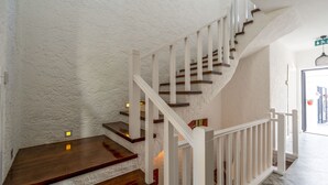 A staircase with wooden steps and white railings, leading to an upper floor. - Portakal Cicegi Alaçatı  (Cesme)