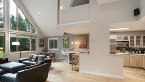 Amplia sala de estar con un sofá grande, mesa de comedor y cocina equipada con electrodomésticos modernos.