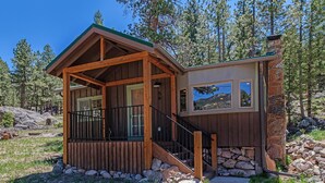 A cabin with a wooden exterior, a stone chimney, and a stone foundation. - Niwot Cabin - Stay In Rocky Mountain National Park - Estes Park - New Listing - 22-zone3298 2 Bedroom Cabin by RedAwning (Estes Park)