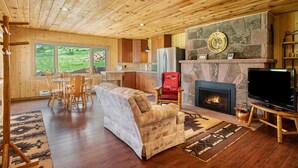A cozy living room with a fireplace, a TV, and a comfortable sofa.