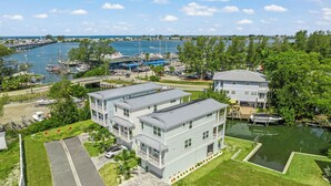 A waterfront property with a marina, a bridge, and a large building with multiple balconies. - Canalfront Home! Near Anna Maria Island (Cortez)