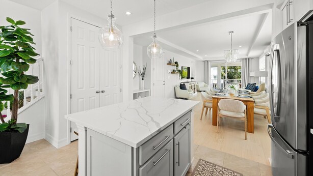 A modern kitchen with a marble island, stainless steel appliances, and pendant lighting. - Canalfront Home! Near Anna Maria Island (Cortez)