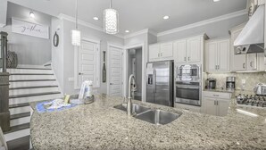 A modern kitchen with granite countertops, stainless steel appliances, and pendant lighting. - ☀️Highland Parks 30A-Pool-Bikes-Barefoot Blessing (Santa Rosa Beach)