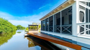 A houseboat with a deck, large windows, and a view of the water. - The Weekender & Mistico Beach Club + Boat Shuttle (San Pedro)