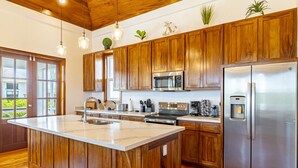 Une cuisine avec des meubles en bois, des appareils en acier inoxydable et un grand îlot central.