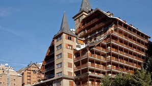 A multi-story hotel with a traditional Alpine architectural style, featuring wooden balconies and a steeply pitched roof. - Port Luxe by FeelFree Rentals (Baqueira)