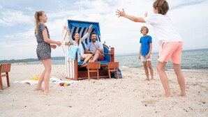 Een strandscène met een strandstoel en iemand die daar in zit.