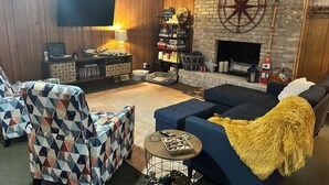 Ein gemütliches Wohnzimmer mit Kamin, Bücherregal und einer großen Wanduhr.