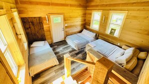 A cabin with four wooden beds arranged in a U-shape, a wooden door, and windows. - ANY BIG PARTY!!!! (Standish)