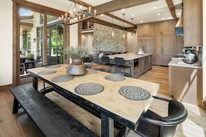 A modern kitchen with a central island, wooden cabinetry, and a stone accent wall.
