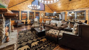 Un acogedor interior de cabaña de madera con chimenea, comedor y cocina.