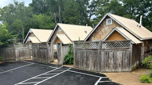 A row of wooden cabins with stone accents, each with a fenced patio area.