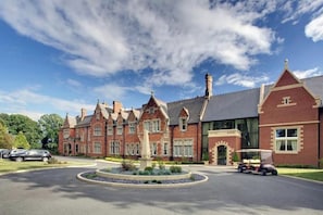 A large, historic building with a central courtyard, a statue, and a well-maintained lawn. - 2 Railway Terrace (Hurworth Place)