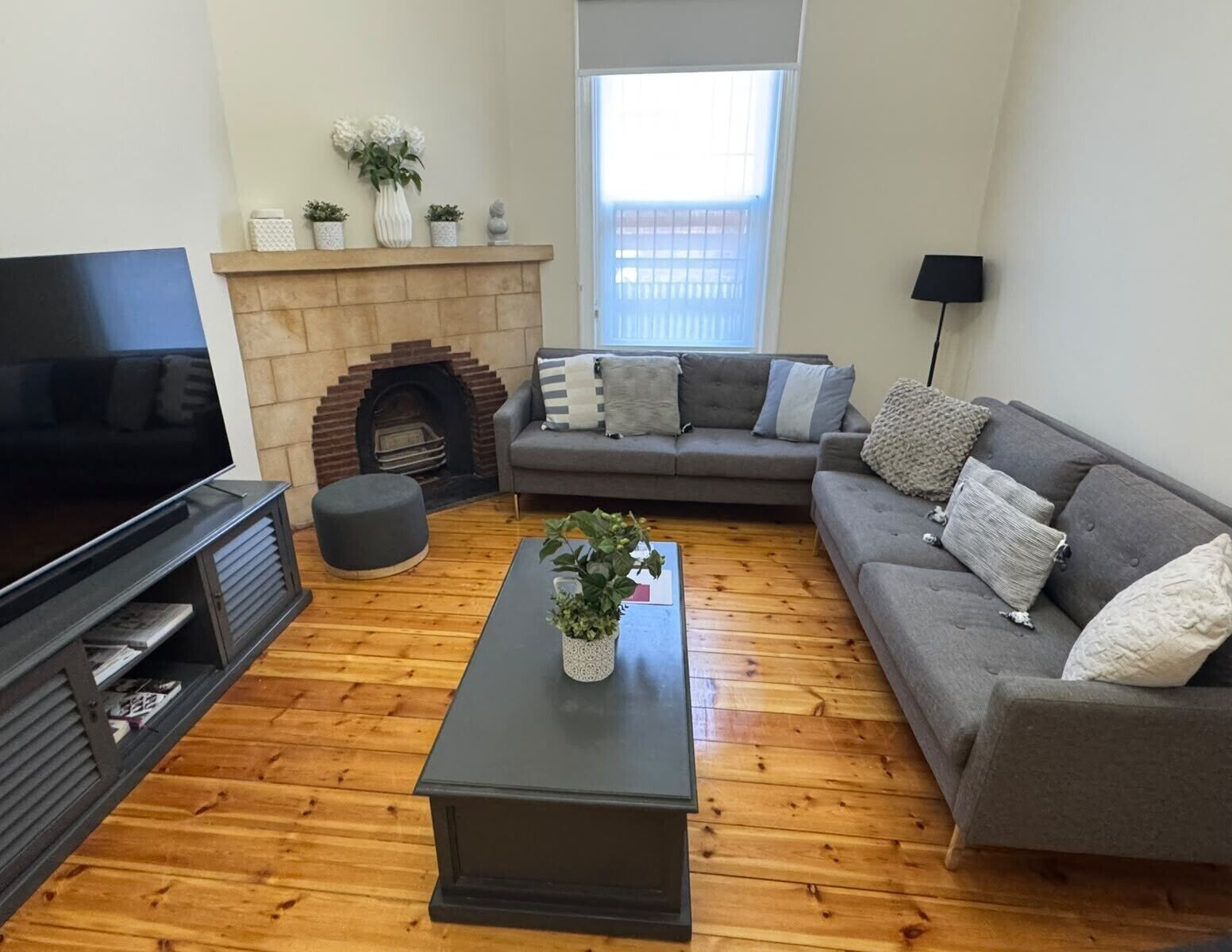 A living room with a fireplace, a sofa, a coffee table, and a television.