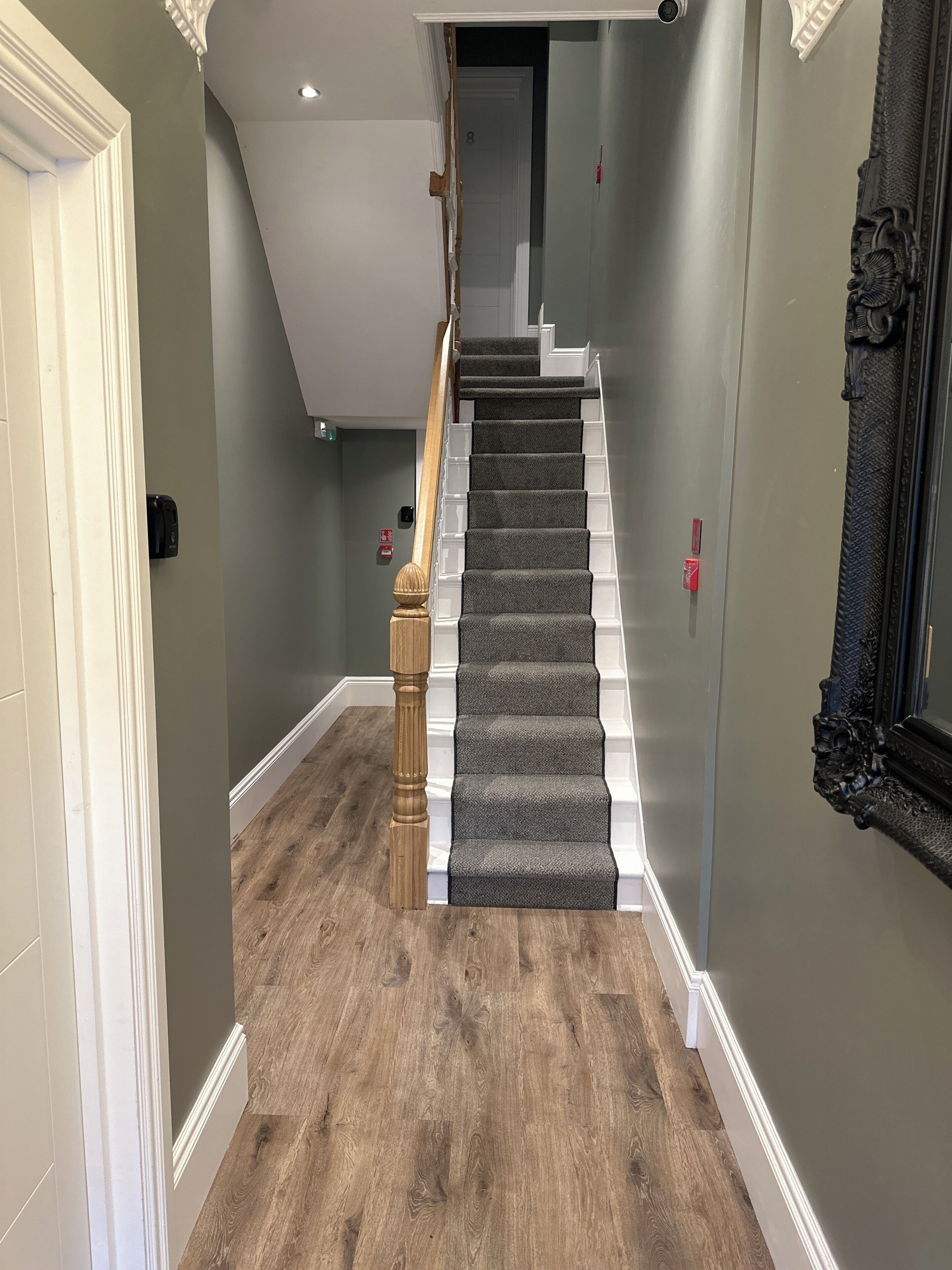 A staircase with wooden balusters and carpeted steps leading to a landing.