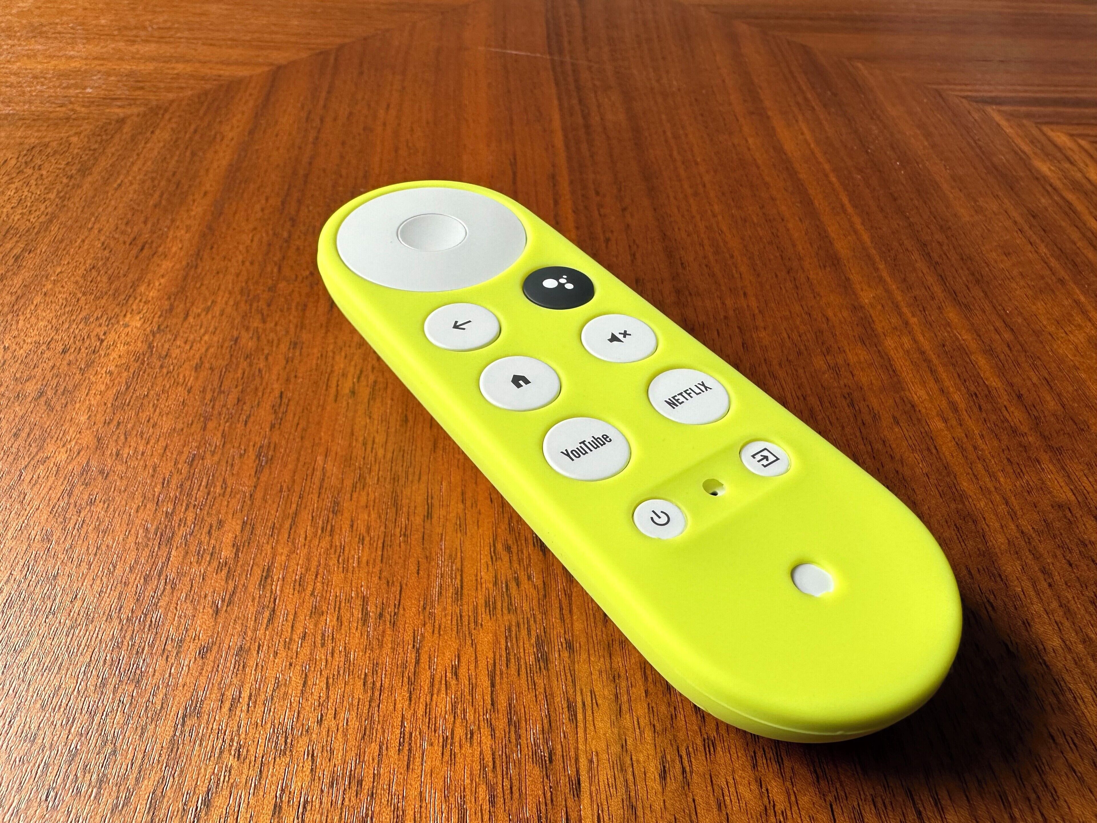 A yellow remote control with buttons labeled "YouTube," "Netflix," and "TV" on a wooden surface.