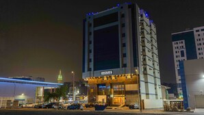 Un hôtel moderne doté d’une entrée imposante, de plusieurs étages et d’une façade illuminée.