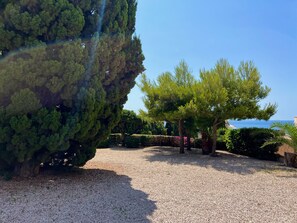 A gravel pathway leading to a seating area with trees and a view of the sea. - Alq 250 Los Castillos de Calpe (Calpe / Calp)